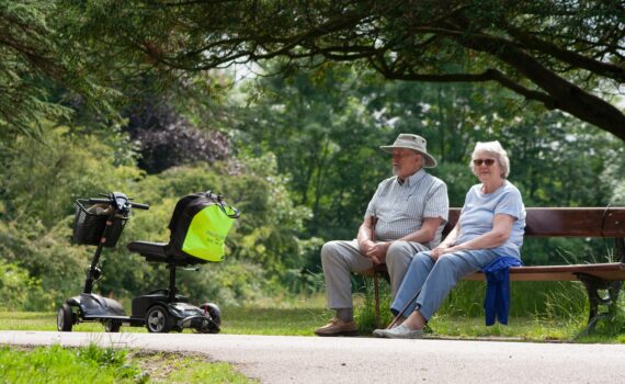 Ældre par på en bænk med en el-scooter
