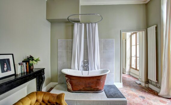 red and white bathtub near yellow fabric sofa