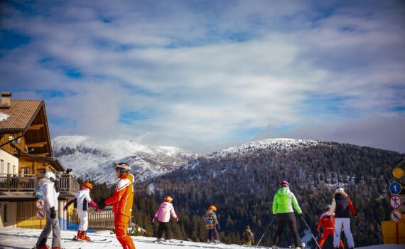 A group of skiers in colorful gear on a snowy mountain slope